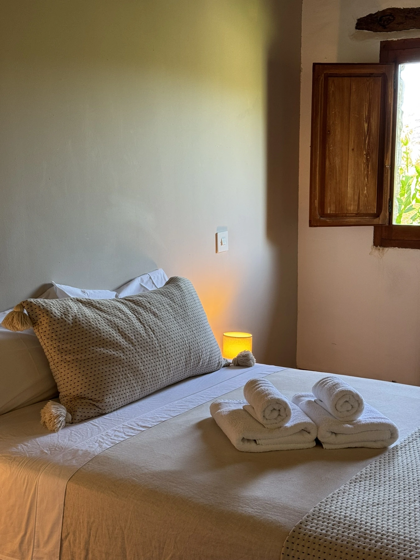 Detalle de la cama de matrimonio y sus toallas en Masía La Costereta