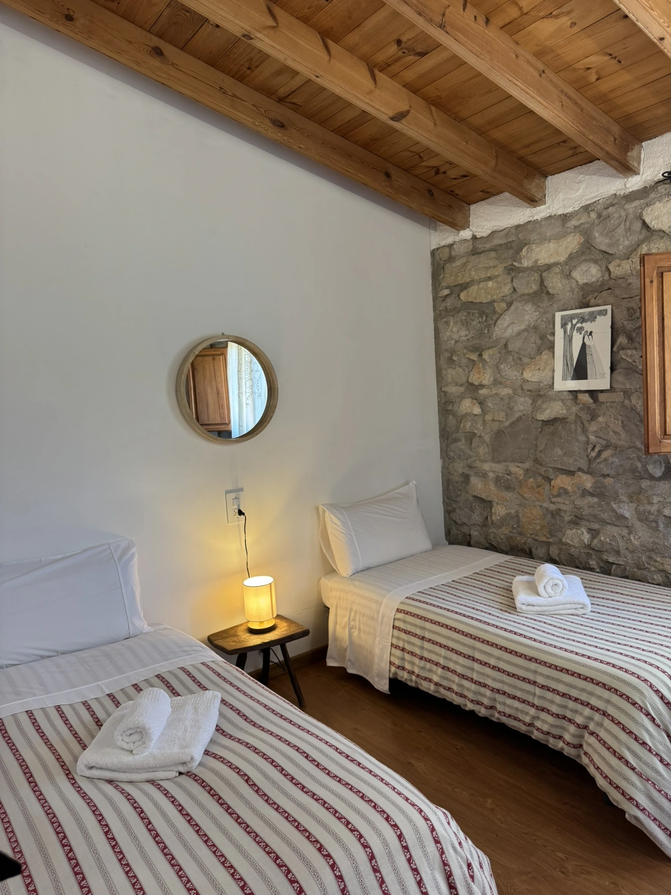 Dormitorio con dos camas individuales y colchas de rayas en Masía La Costereta