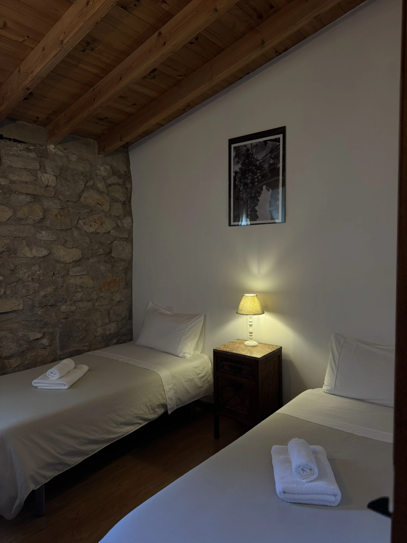Habitación de dos camas junto a la pared de piedra en Masía La Costereta
