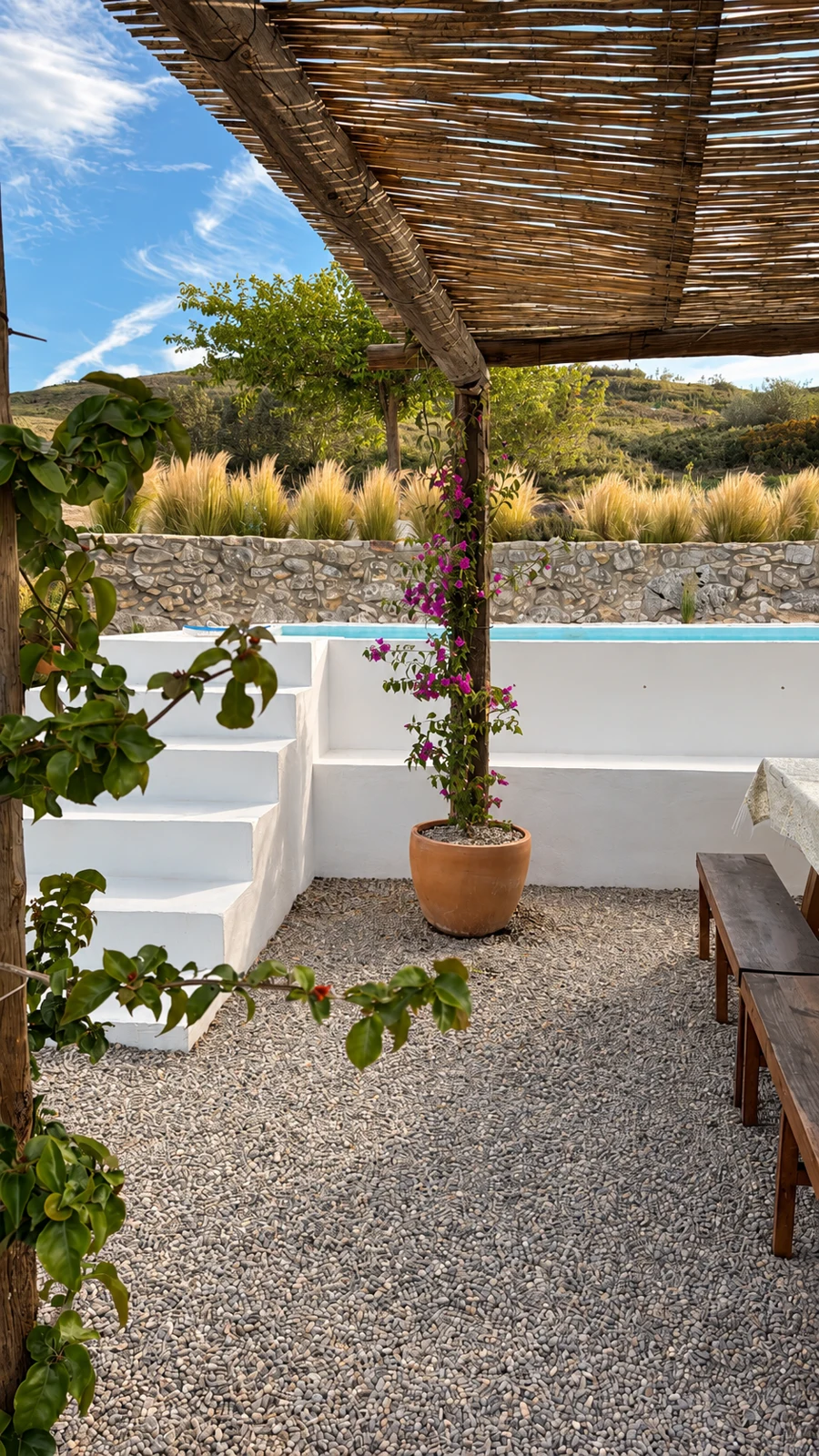 Porche de cañizo con buganvilla junto a la piscina de Masía La Costereta