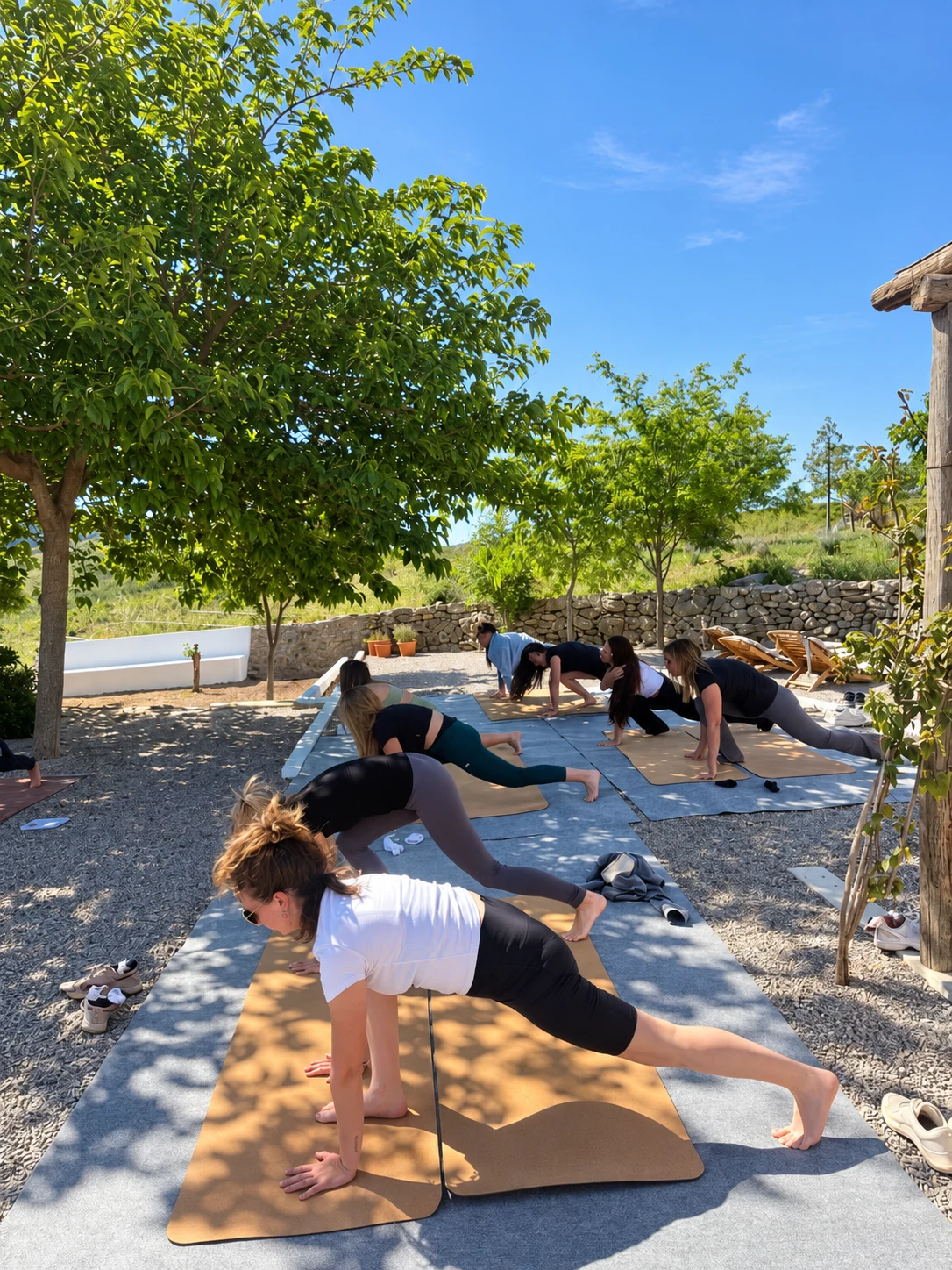 Sesión de yoga al aire libre durante un retiro en la masía
